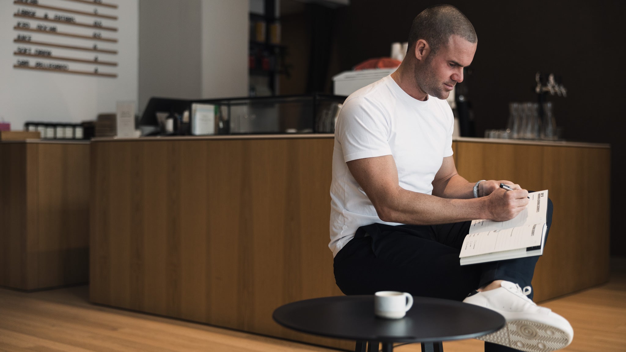 Male journalling at a cafe